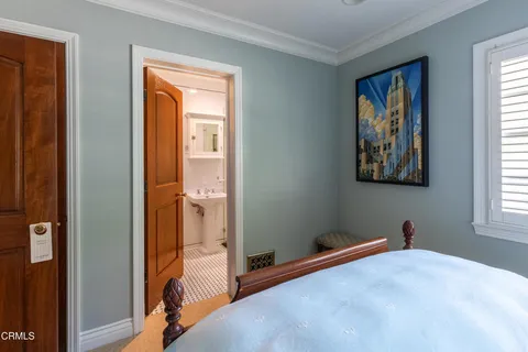 a room with kitchen island a large window cabinets a sink and stainless steel appliances