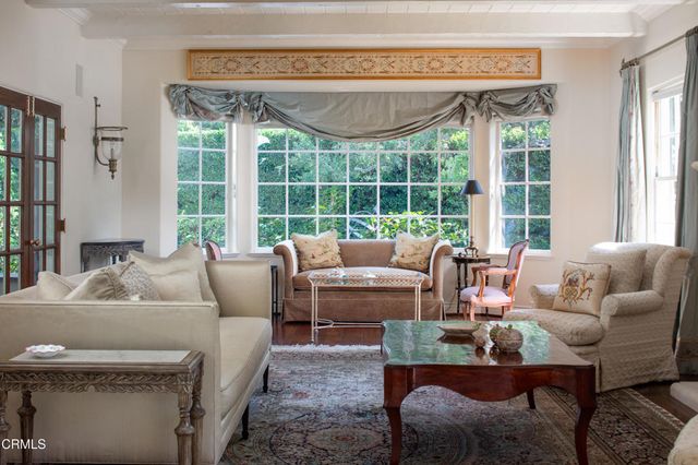 a living room with furniture wooden floor and a table