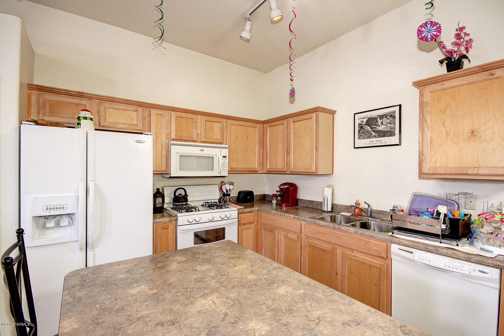 6016 South Avenida Ribero Tucson, AZ 85706 - Photo 5 of 15 a kitchen with granite countertop a refrigerator a sink stainless steel appliances and cabinets