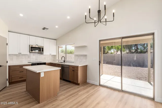 a kitchen with stainless steel appliances granite countertop a sink a stove top oven a counter space and cabinets