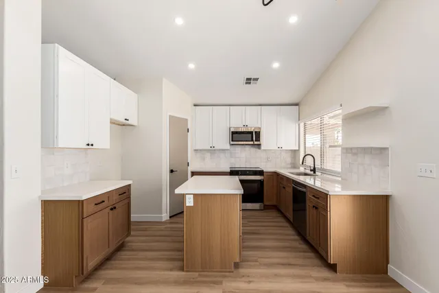 a large kitchen with stainless steel appliances lots of counter space and wooden floor