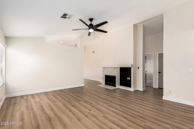 a view of empty room with wooden floor and fireplace