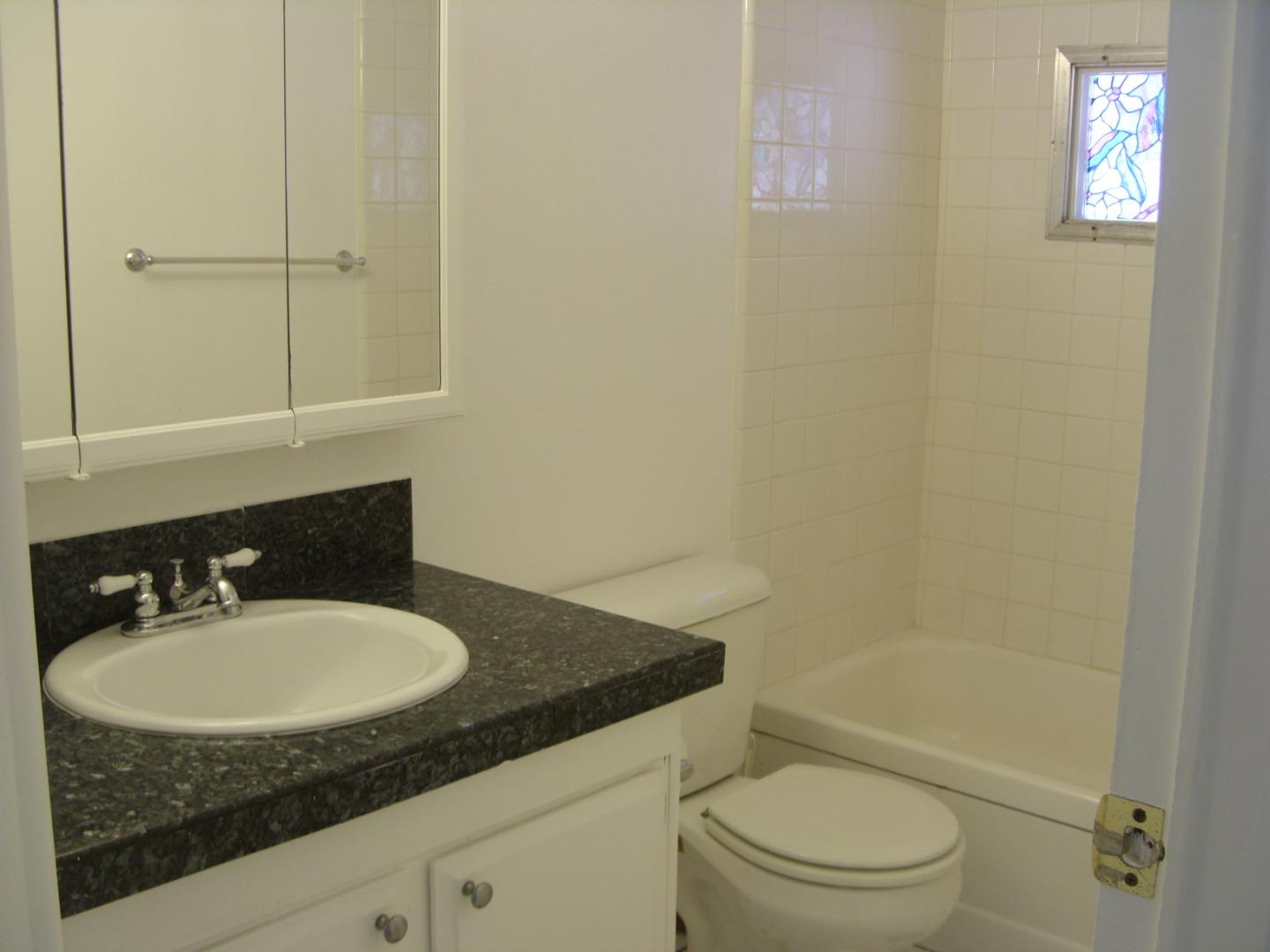 1117 Baldwin Street, Unit 74 Salinas, CA 93906 - Photo 10 of 13 a bathroom with a granite countertop sink toilet and shower