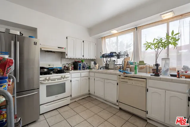 a kitchen with white cabinets and white appliances