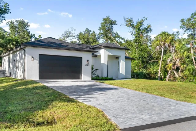 a kitchen with stainless steel appliances granite countertop a sink a refrigerator a stove a washer and dryer with wooden floor