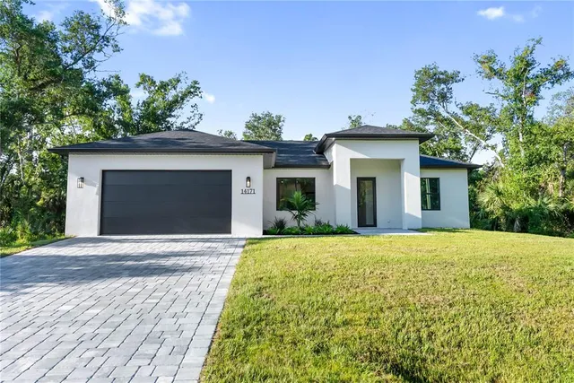 a kitchen with stainless steel appliances granite countertop a refrigerator a sink dishwasher a stove and a oven with wooden floor