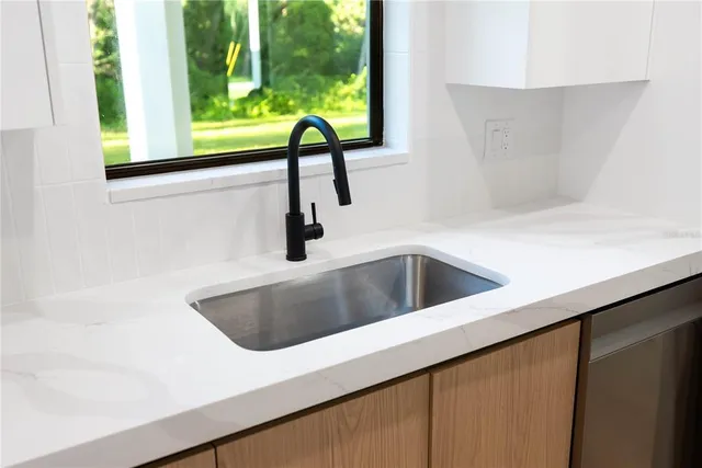 a kitchen with stainless steel appliances a refrigerator sink and white cabinets