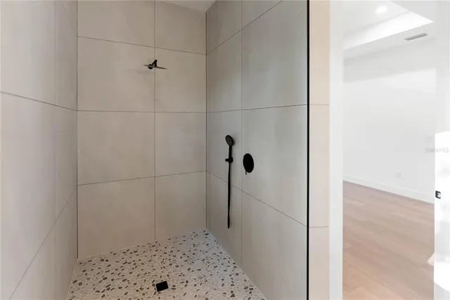 a living room with stainless steel appliances kitchen island granite countertop a refrigerator a sink a oven with a dining table and chairs