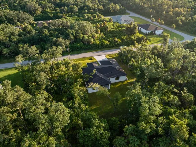 a front view of house with yard and trees in the background
