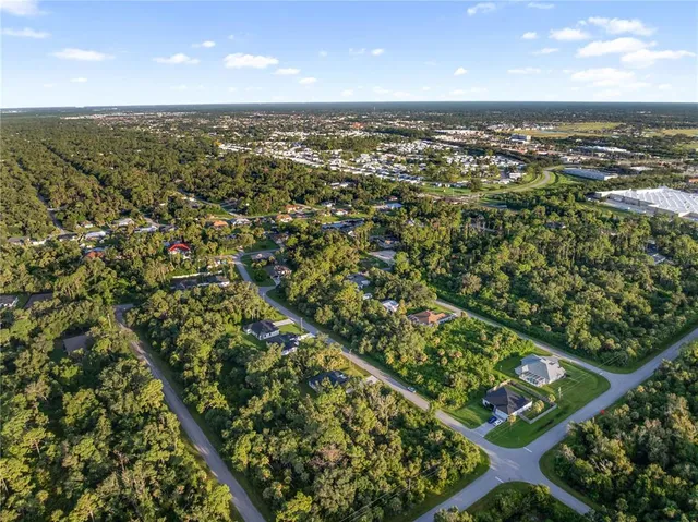 an aerial view of residential houses with outdoor space and trees