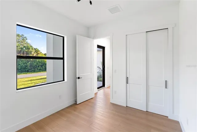 an empty room with a window and a ceiling fan