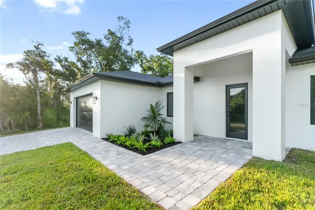 a view of an empty room with a window and hardwood floor