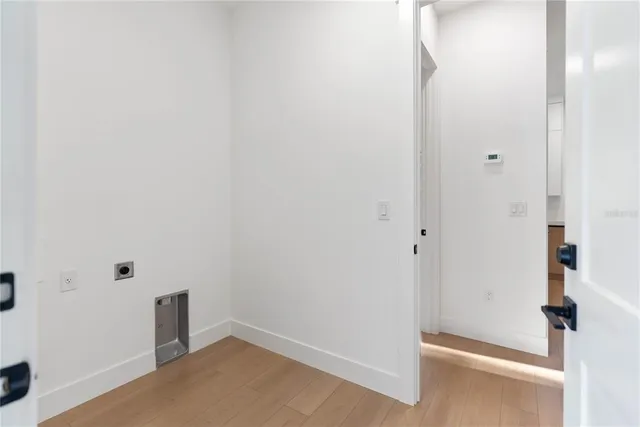 an empty room with a window and wooden floor