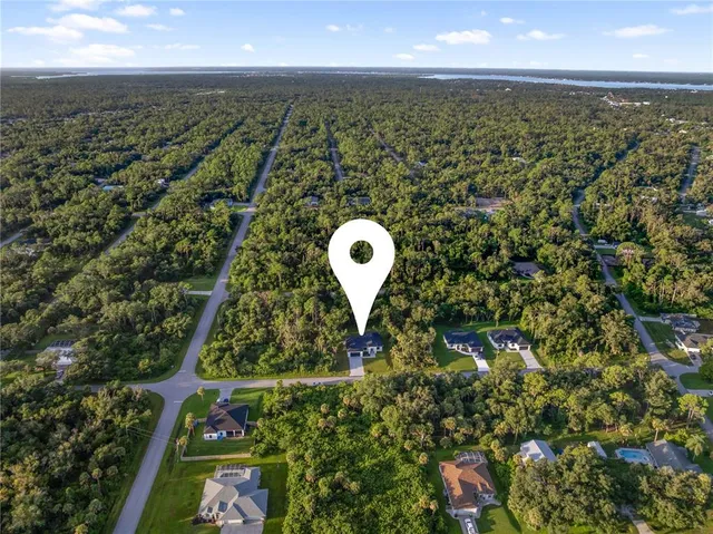 an aerial view of a house with a garden and trees