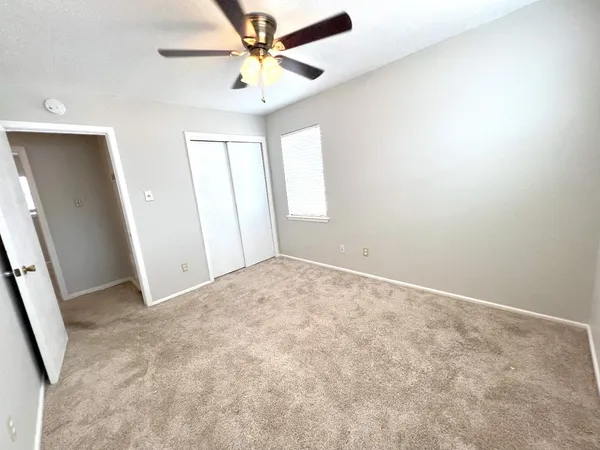 an empty room with windows and fan