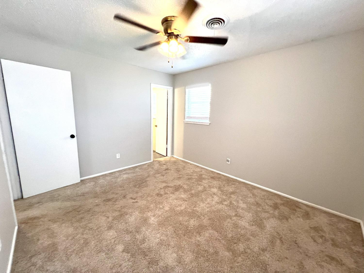 5540 18th Street Lubbock, TX 79416 - Photo 17 of 18 an empty room with a window and a fan