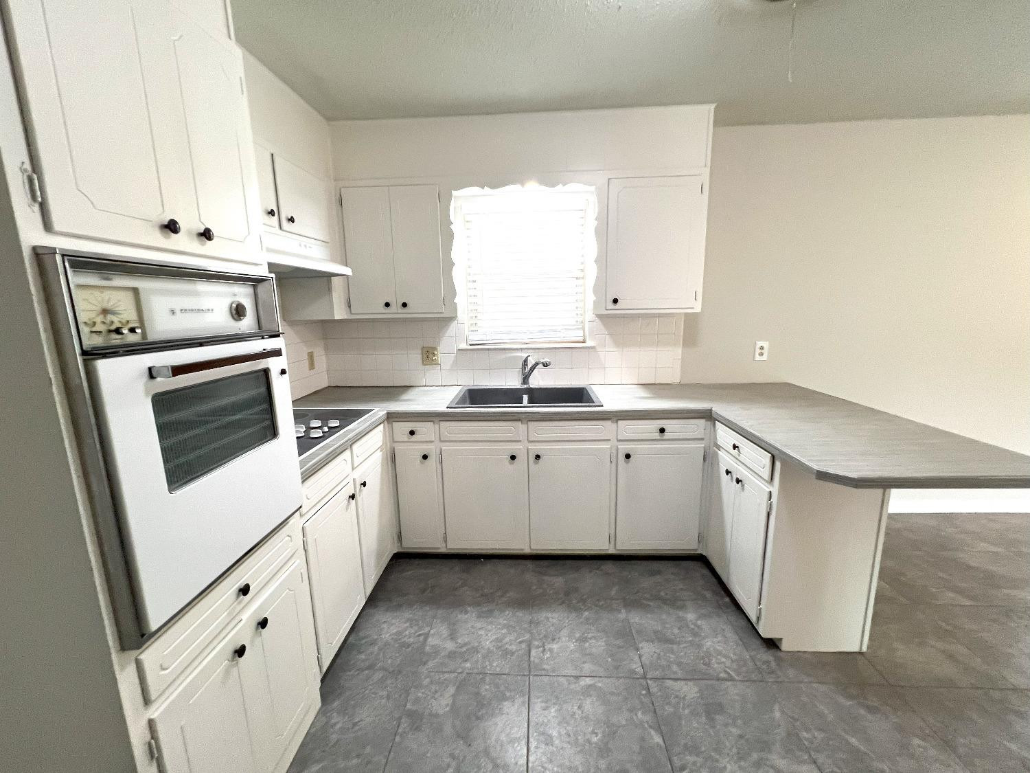 5540 18th Street Lubbock, TX 79416 - Photo 8 of 18 a kitchen with granite countertop white cabinets and white appliances