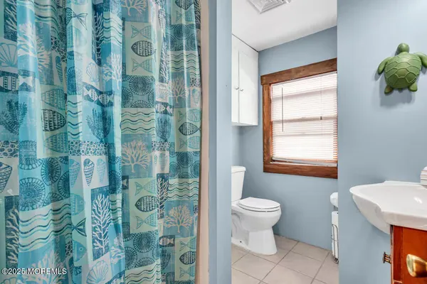 a bedroom with a bed table chair and a window