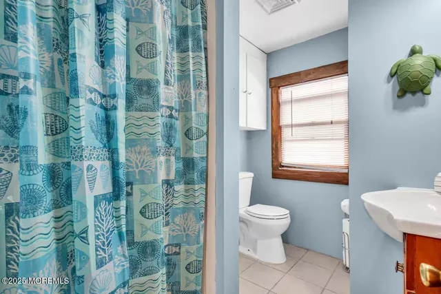 a bedroom with a bed table chair and a window