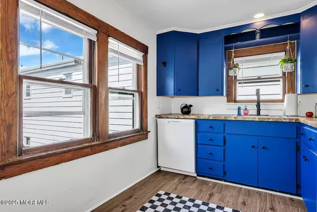 a kitchen with stainless steel appliances granite countertop wooden cabinets a sink and dishwasher with wooden floor