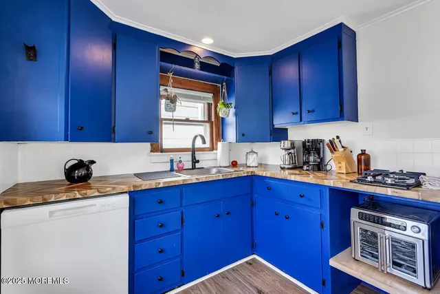 a kitchen with granite countertop wooden cabinets a sink a window and stainless steel appliances