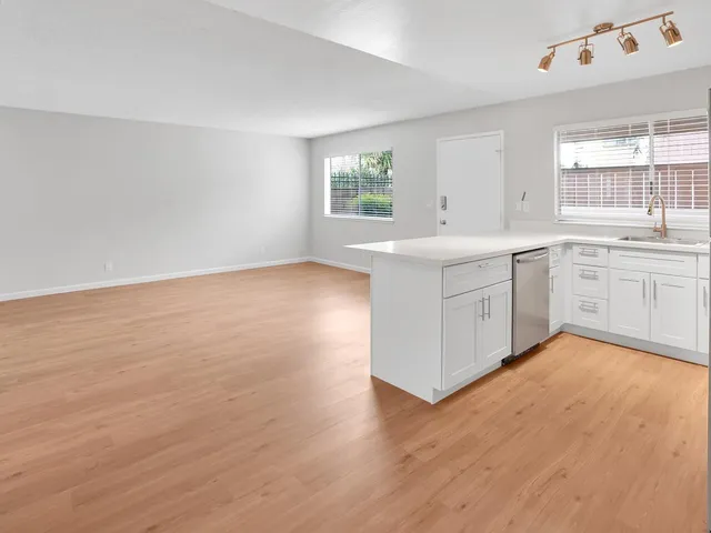 a view of cabinets a kitchen island wooden floor and a window