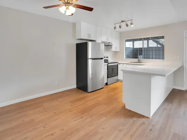 a kitchen with stainless steel appliances granite countertop a refrigerator a stove a sink and a microwave