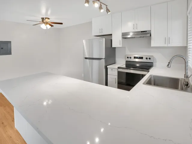a kitchen with stainless steel appliances a refrigerator sink and cabinets