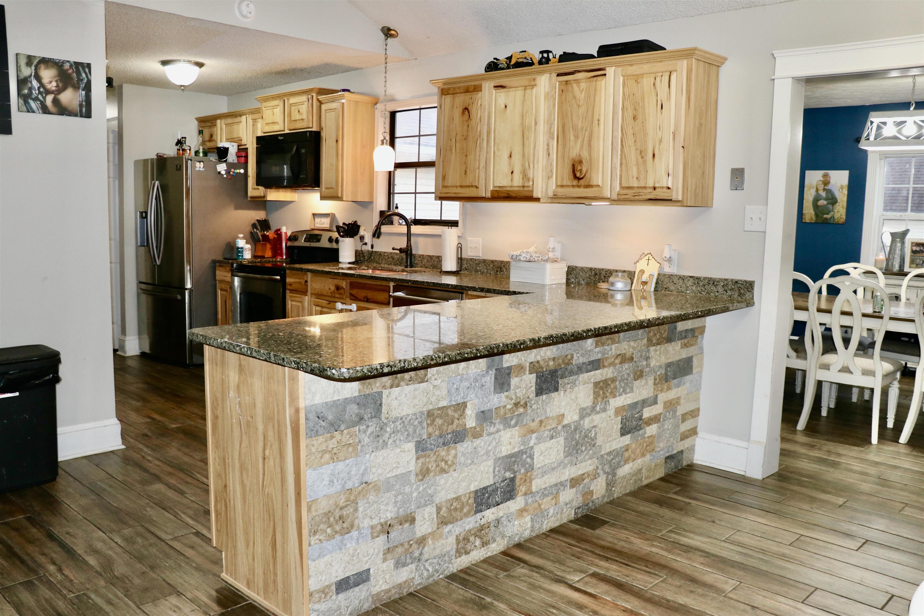 235 Tate Road Dyersburg, TN 38024 - Photo 5 of 28 a kitchen with stainless steel appliances granite countertop a refrigerator a stove top oven a sink and dishwasher