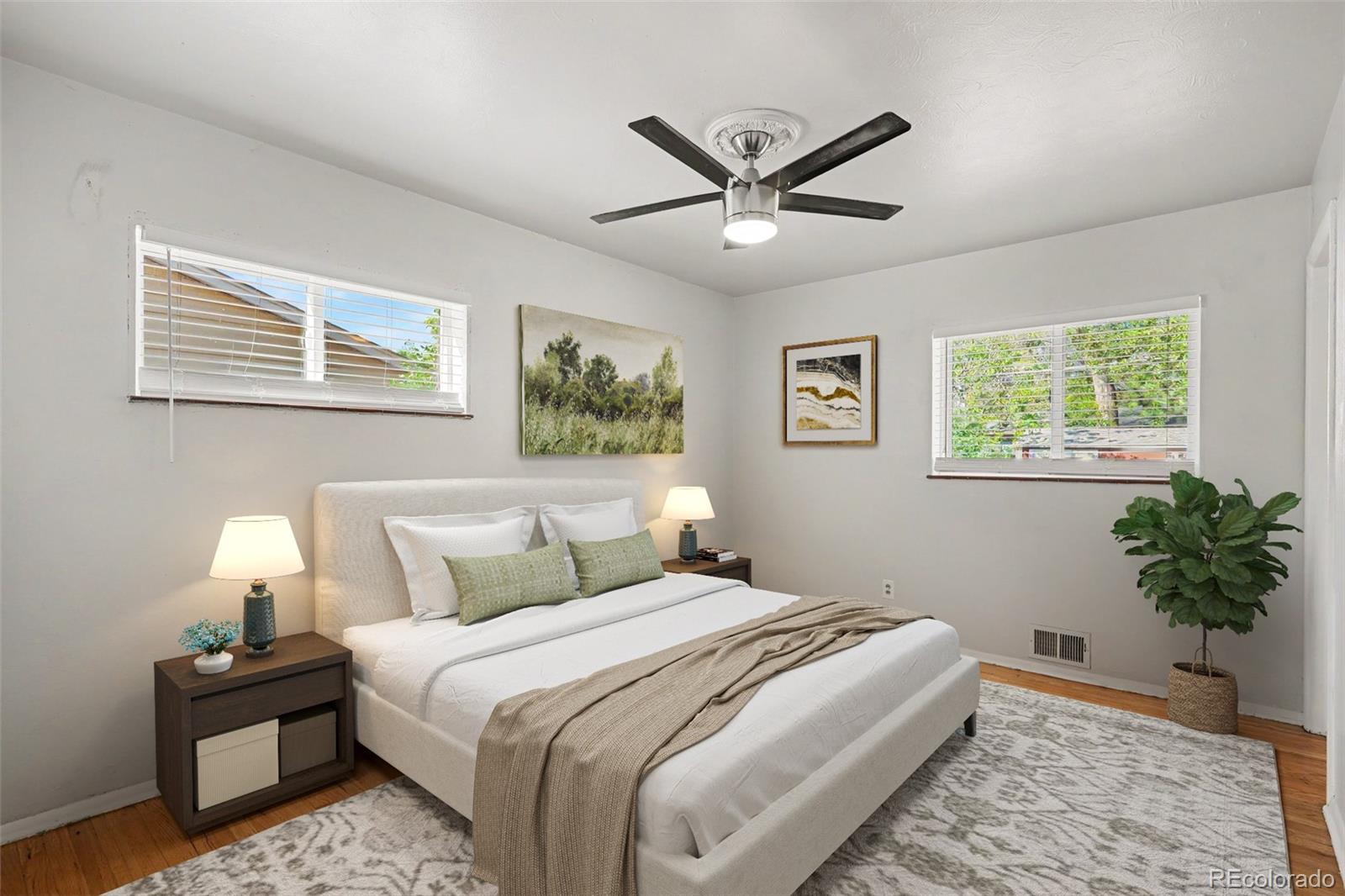 3217 South Stuart Street Denver, CO 80236 - Photo 15 of 29 a bedroom with a bed lamp and a potted plant