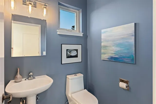 a living room with furniture and a painting on the wall