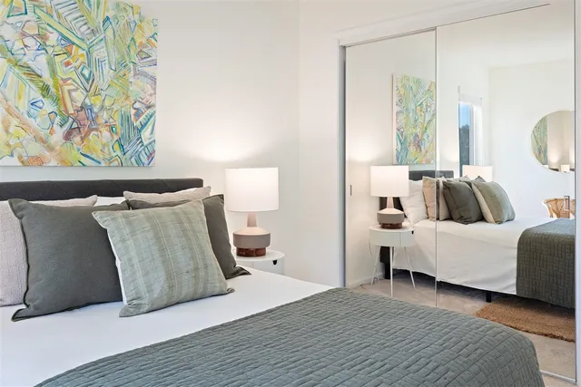 a bedroom with a bed and a painting on the wall