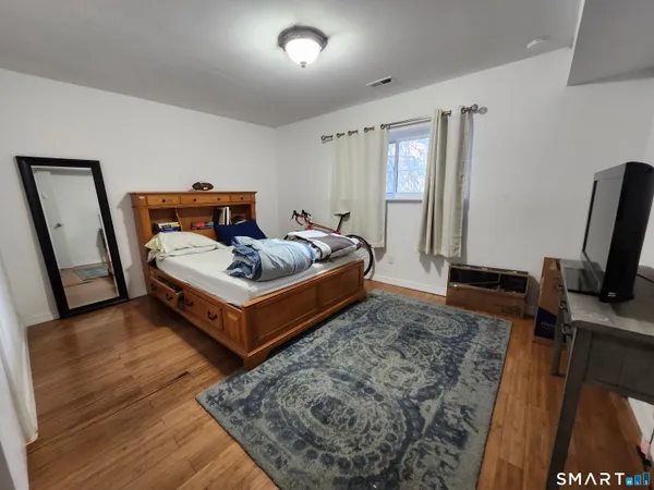 a bedroom with a bed and wooden floor