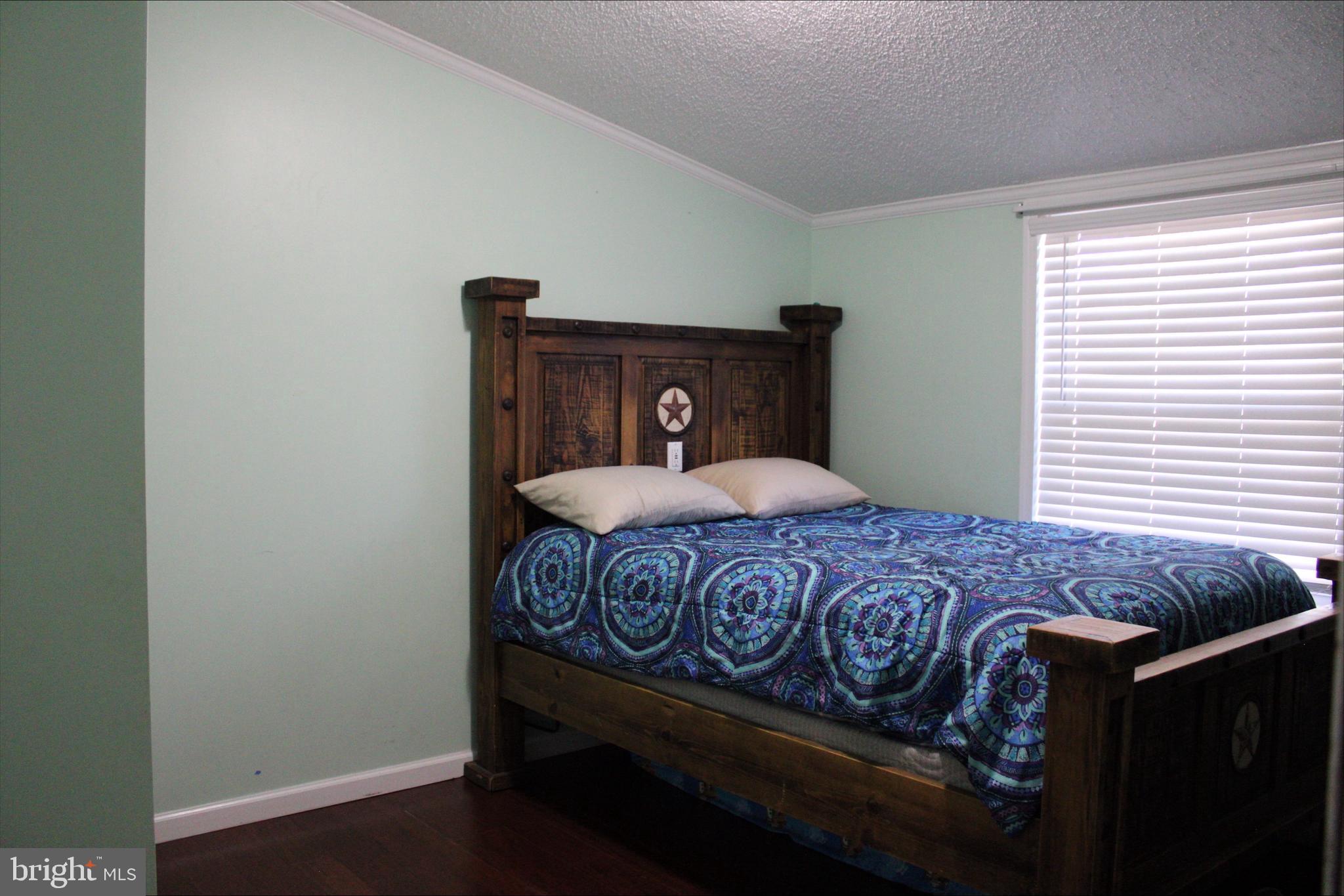 1061 South Little Creek Road, Unit 200 Dover, DE 19901 - Photo 17 of 21 a bed sitting in a bedroom next to a window