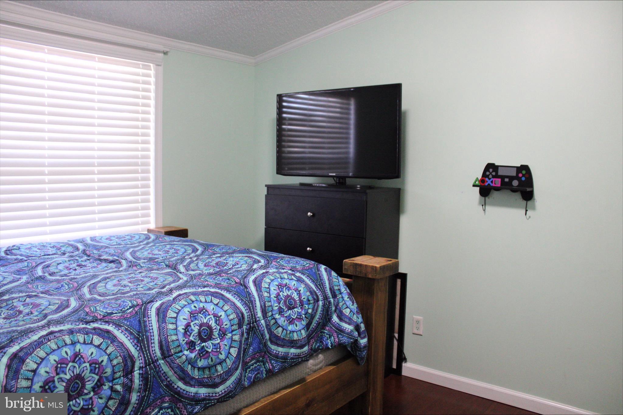 1061 South Little Creek Road, Unit 200 Dover, DE 19901 - Photo 19 of 21 a bedroom with a bed and wooden floor