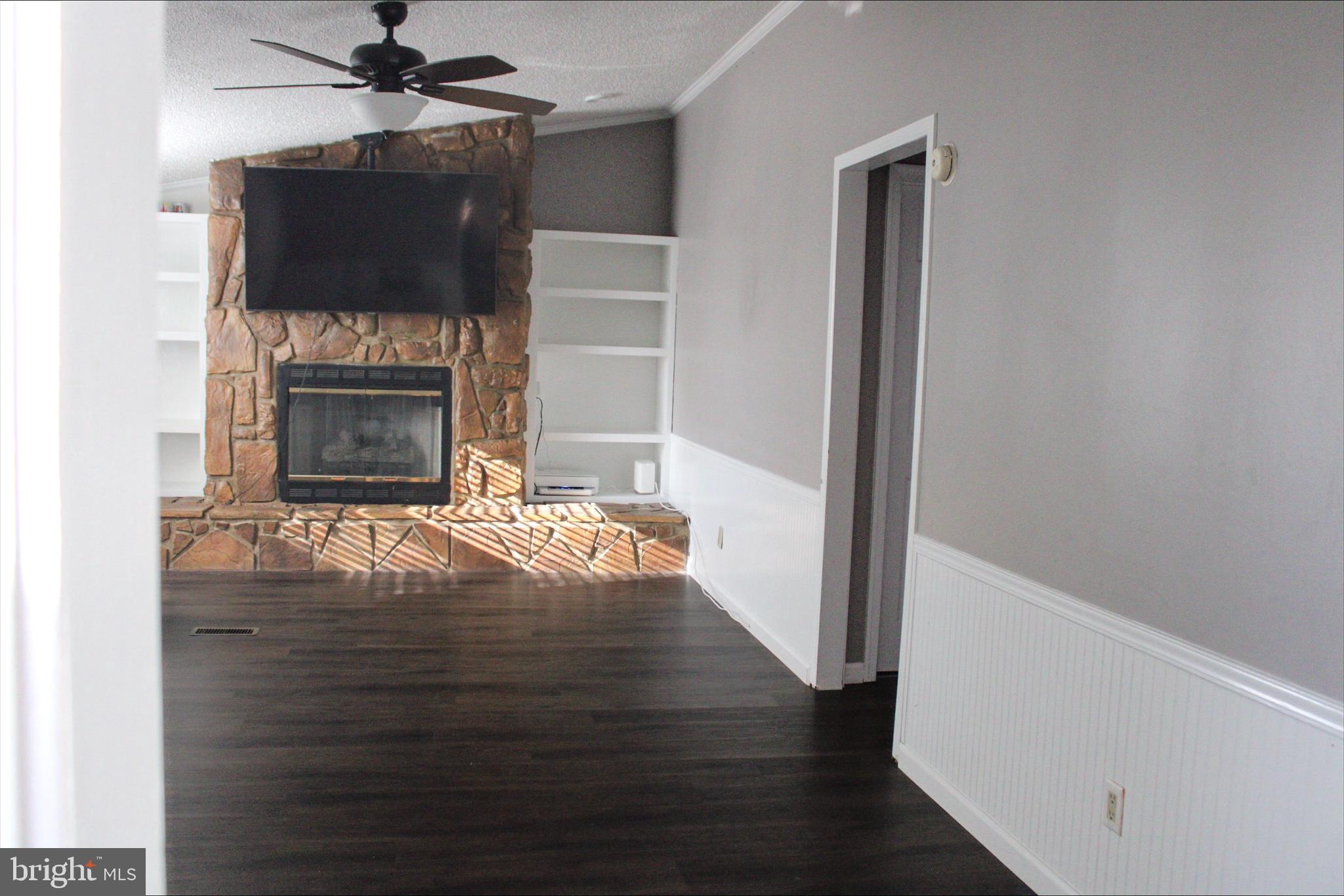 1061 South Little Creek Road, Unit 200 Dover, DE 19901 - Photo 6 of 21 a view of a livingroom with wooden floor a ceiling fan and a fireplace