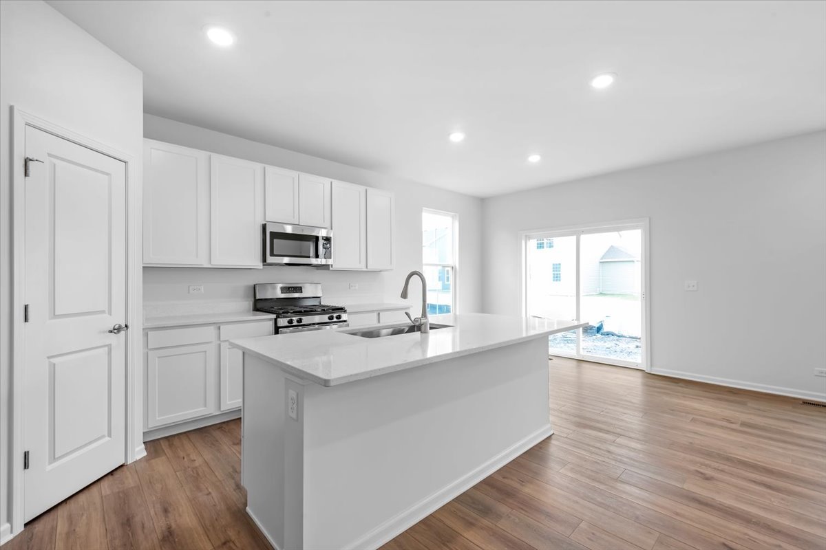 87 Hedgerow Drive Elgin, IL 60124 - Photo 11 of 52 a kitchen with stainless steel appliances granite countertop a sink stove and refrigerator