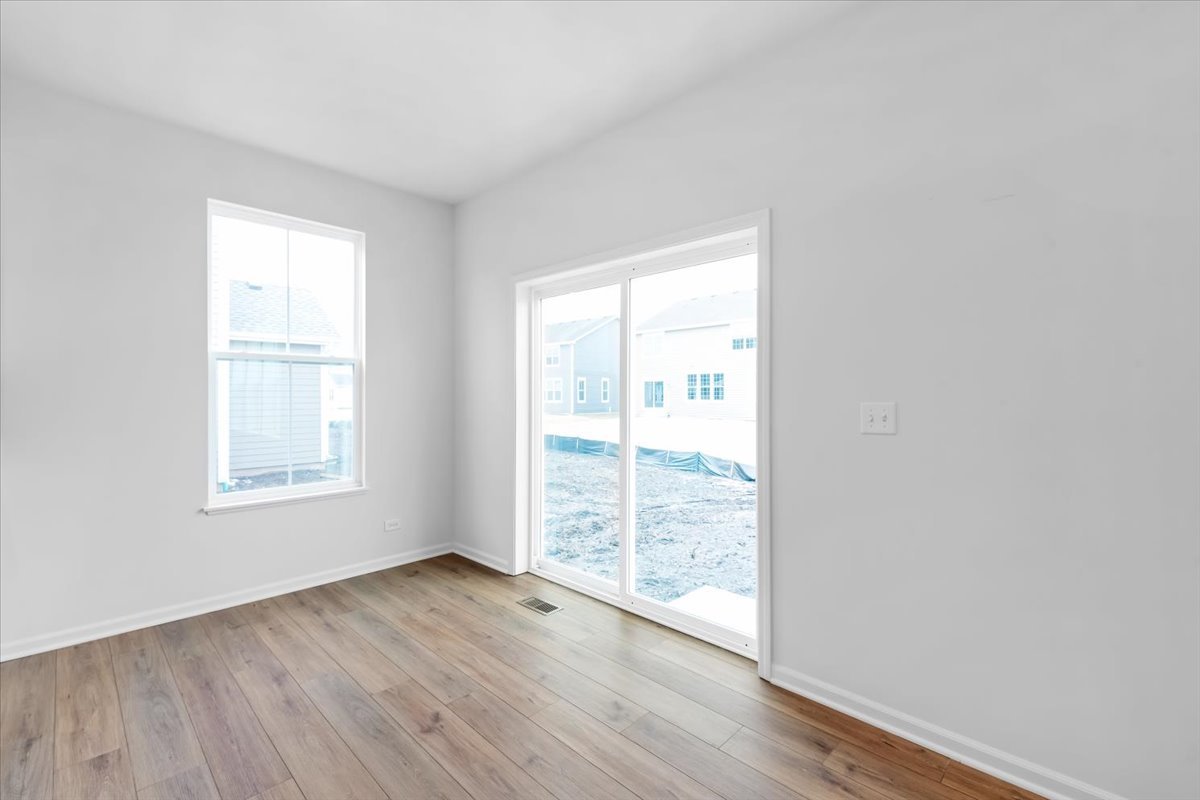 87 Hedgerow Drive Elgin, IL 60124 - Photo 18 of 52 an empty room with wooden floor and windows