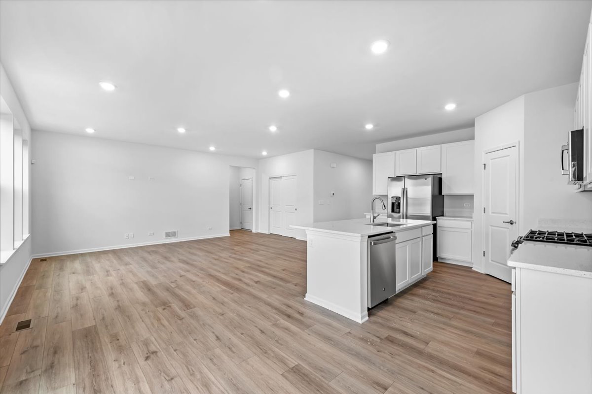 87 Hedgerow Drive Elgin, IL 60124 - Photo 10 of 52 a large kitchen with a center island wooden floor stainless steel appliances and cabinets