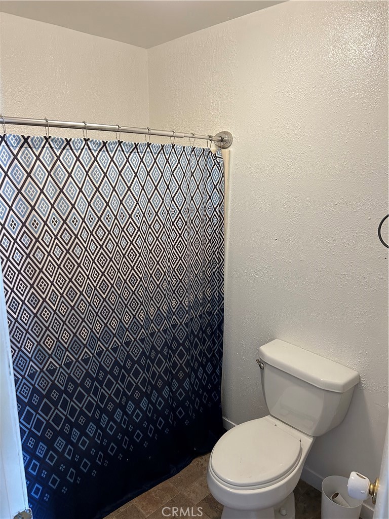 312 West Cedar Street Willows, CA 95988 - Photo 5 of 21 a white toilet sitting next to a shower curtain