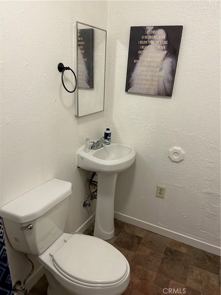 312 West Cedar Street Willows, CA 95988 - Photo 6 of 21 a white toilet sitting next to a bathroom sink