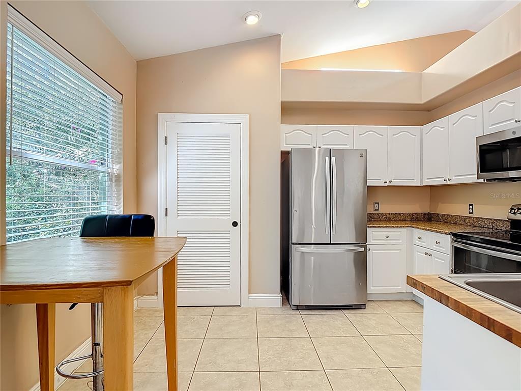 2730 68th Avenue Northeast Naples, FL 34120 - Photo 19 of 86 a kitchen with stainless steel appliances granite countertop a refrigerator a stove a sink and a microwave