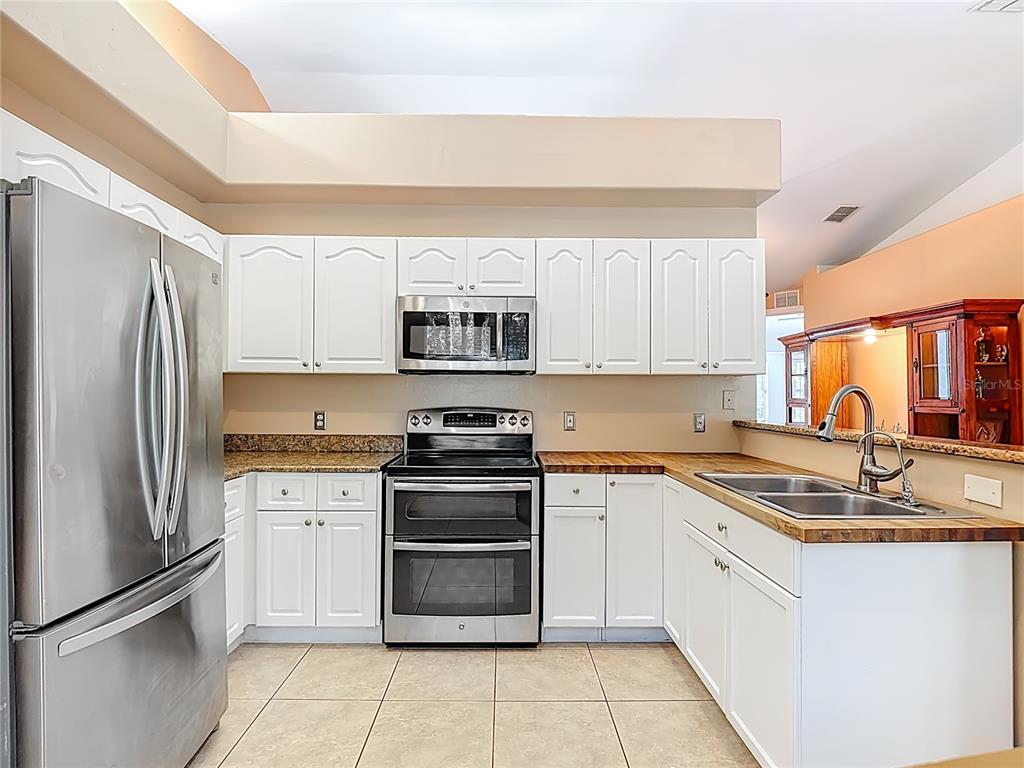 2730 68th Avenue Northeast Naples, FL 34120 - Photo 22 of 86 a kitchen with stainless steel appliances granite countertop a stove a sink and a refrigerator