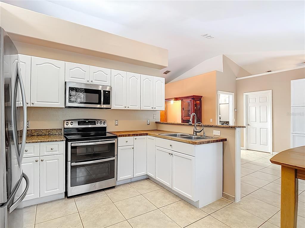 2730 68th Avenue Northeast Naples, FL 34120 - Photo 23 of 86 a kitchen with stainless steel appliances granite countertop a stove top oven a sink dishwasher and a refrigerator