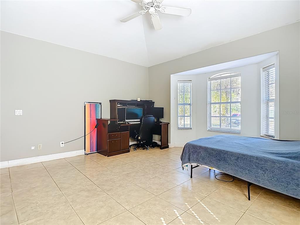 2730 68th Avenue Northeast Naples, FL 34120 - Photo 29 of 86 a bedroom with a bed and a chandelier