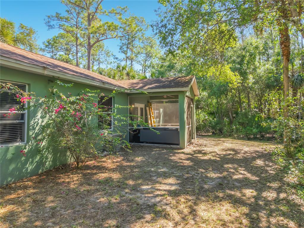 2730 68th Avenue Northeast Naples, FL 34120 - Photo 53 of 86 a view of a house with a small yard and a large tree