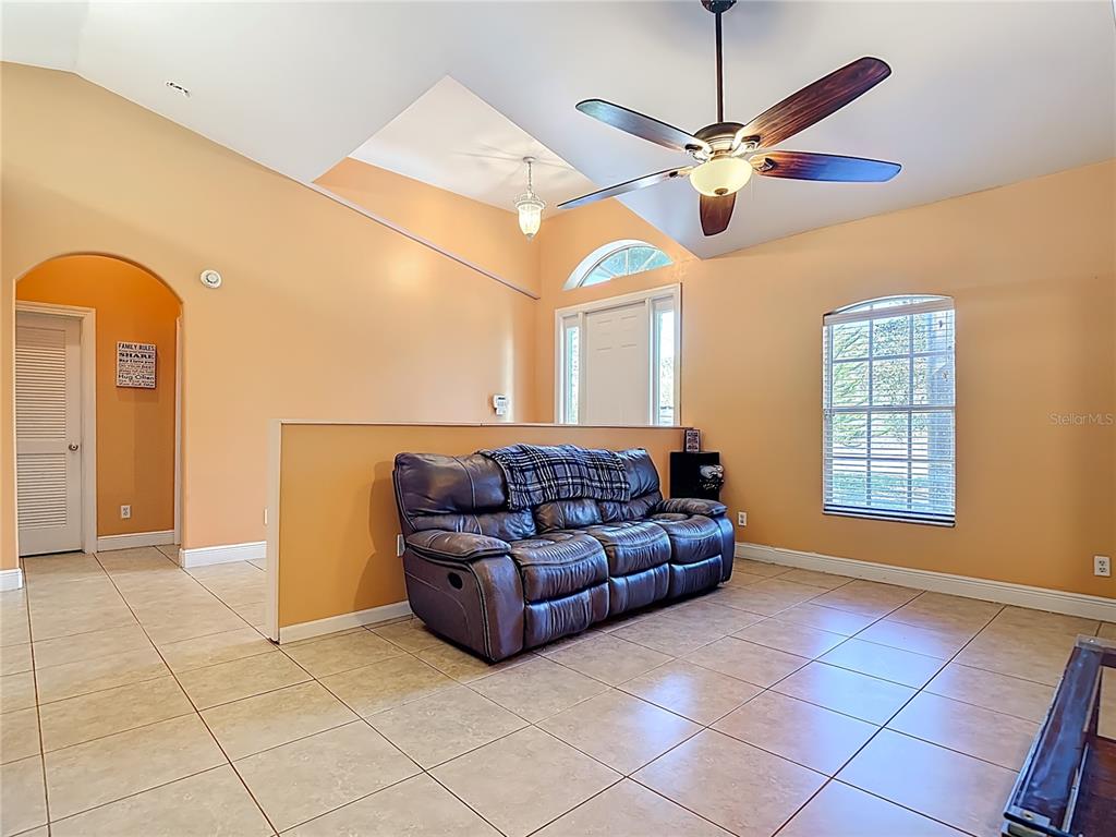 2730 68th Avenue Northeast Naples, FL 34120 - Photo 9 of 86 a living room with a couch and chandelier