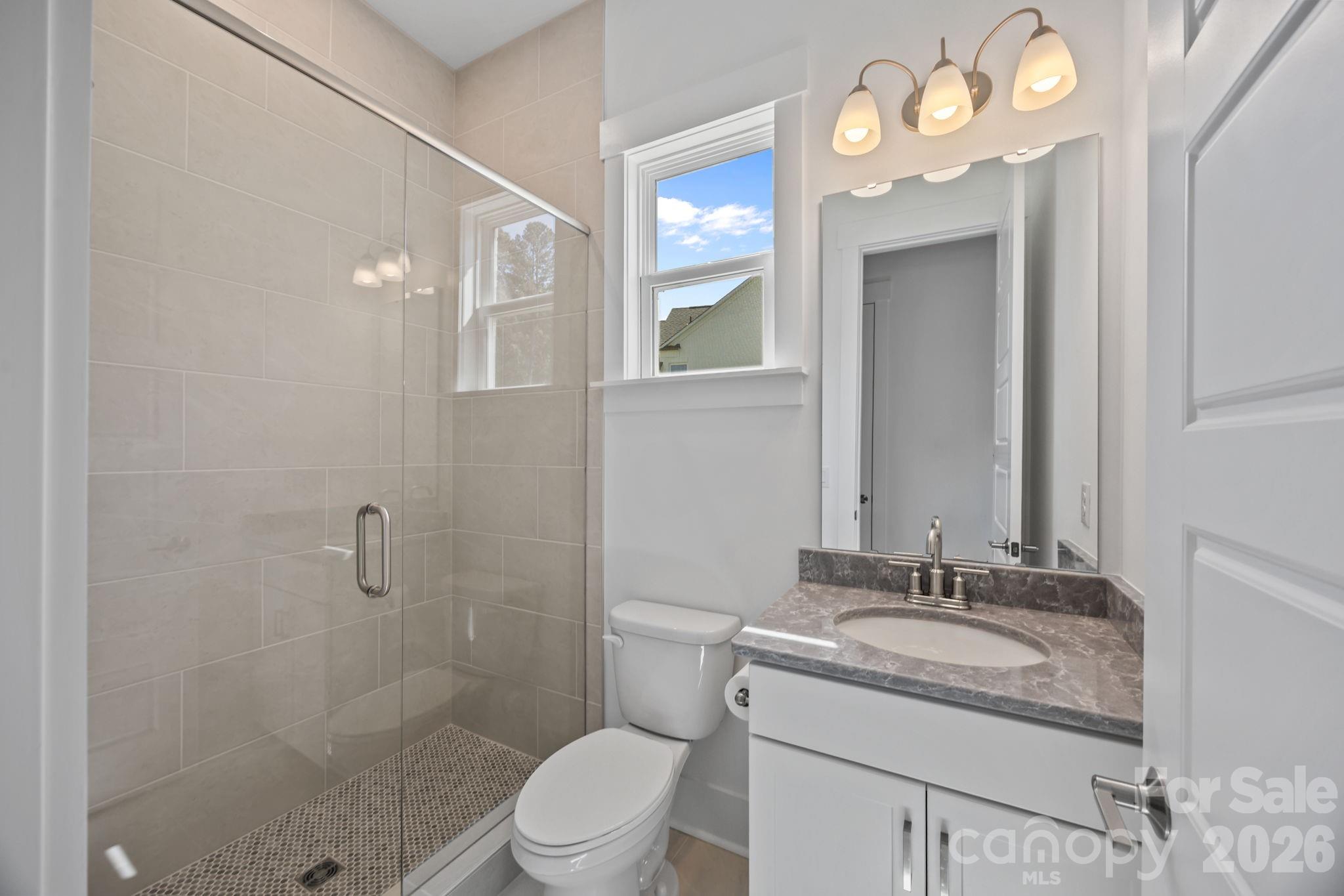 8620 Balcony Bridge Road Huntersville, NC 28078 - Photo 13 of 48 a bathroom with a granite countertop sink a toilet a mirror a vanity and shower