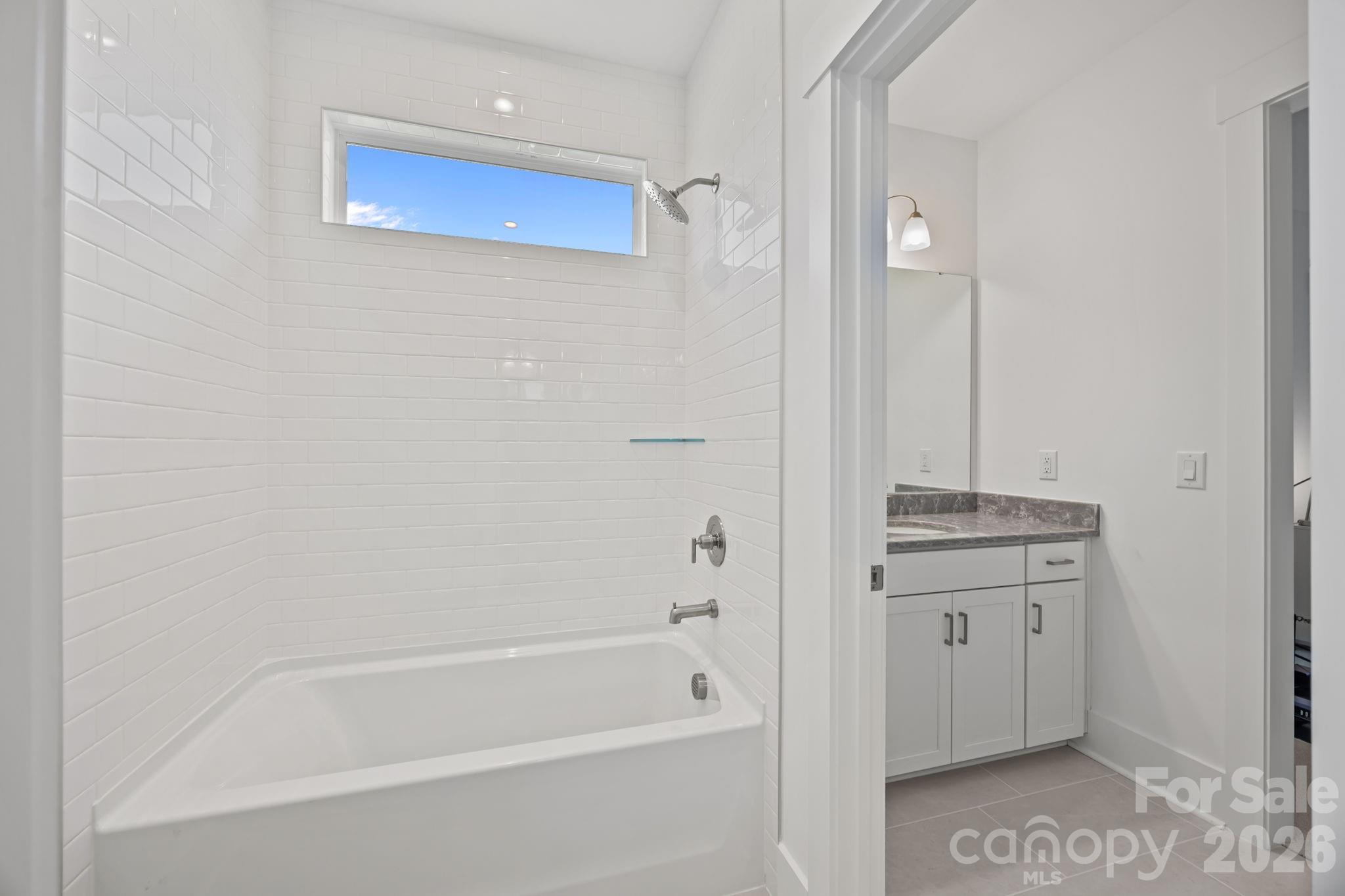 8620 Balcony Bridge Road Huntersville, NC 28078 - Photo 37 of 48 a bathroom with a granite countertop sink a mirror and a bathtub