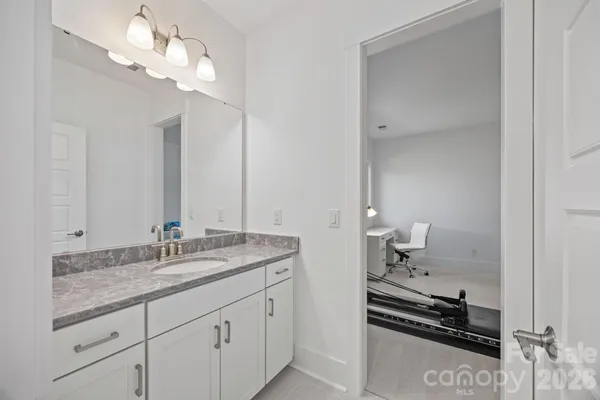 a bathroom with a granite countertop double vanity sink and a mirror